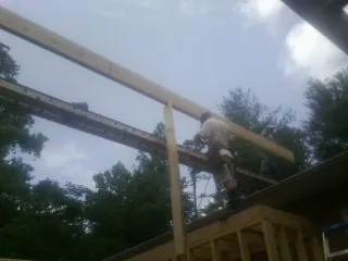 Carpenter setting a ridge beam over a new addition frame — Ice Dam Removal by Roofing Brothers in La Valle