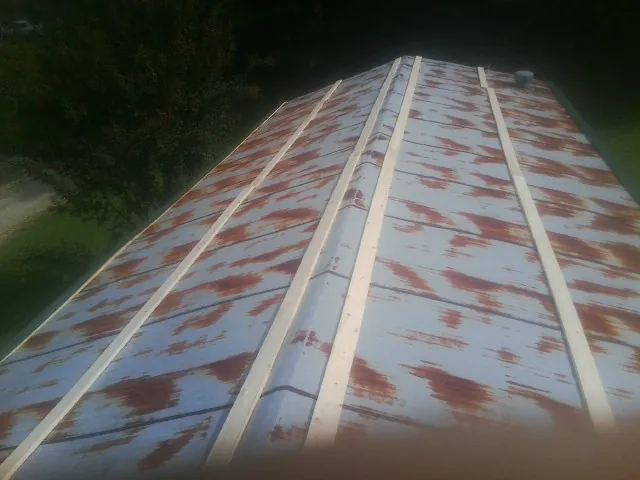 Rusted metal roof panels with new wood purlins before replacement — Storm Damage Roof Repair in La Valle by Roofing Brothers