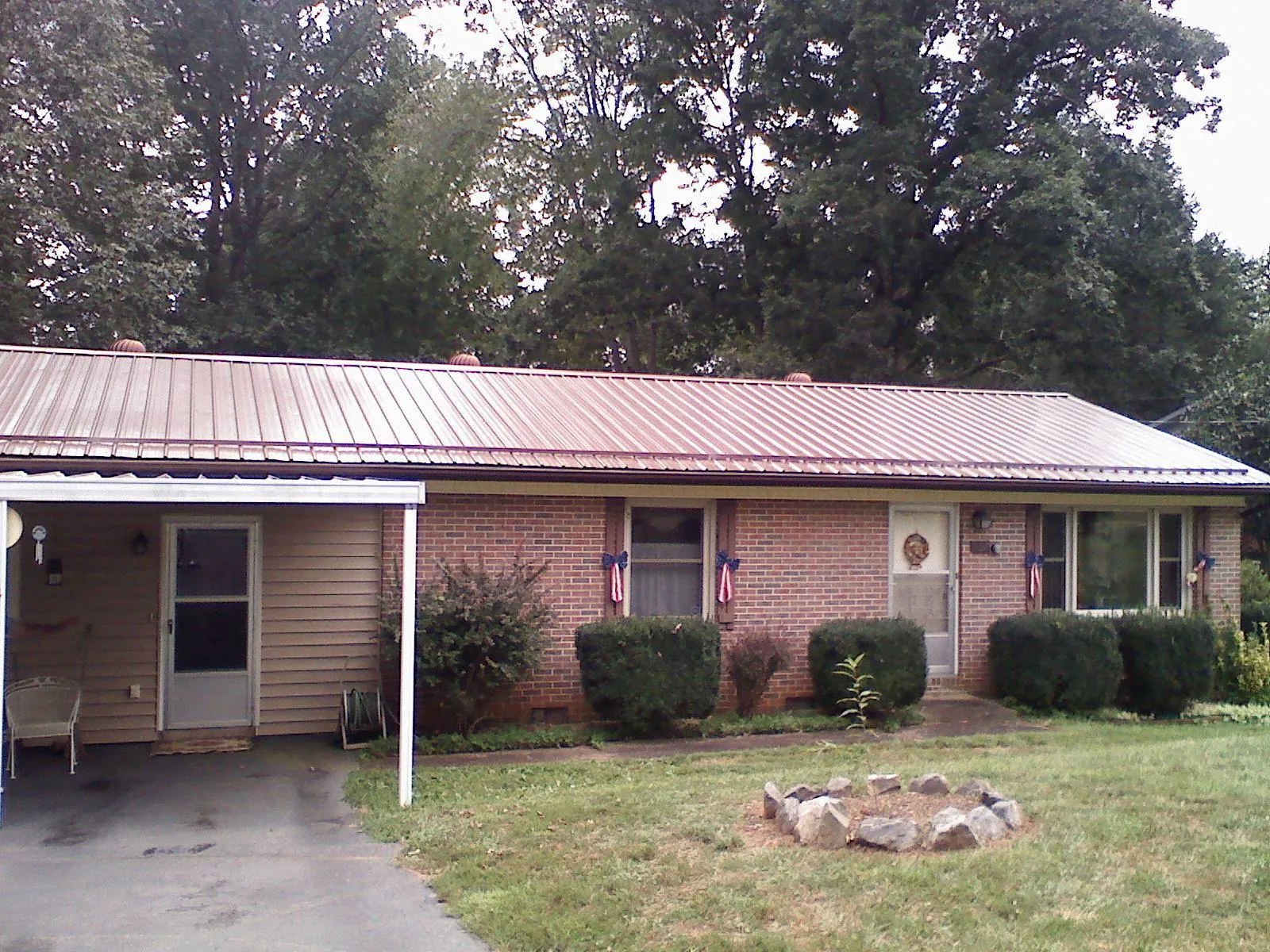 Bronze metal roof and carport on a brick ranch home — Roof Repair work by our crew in La Valle