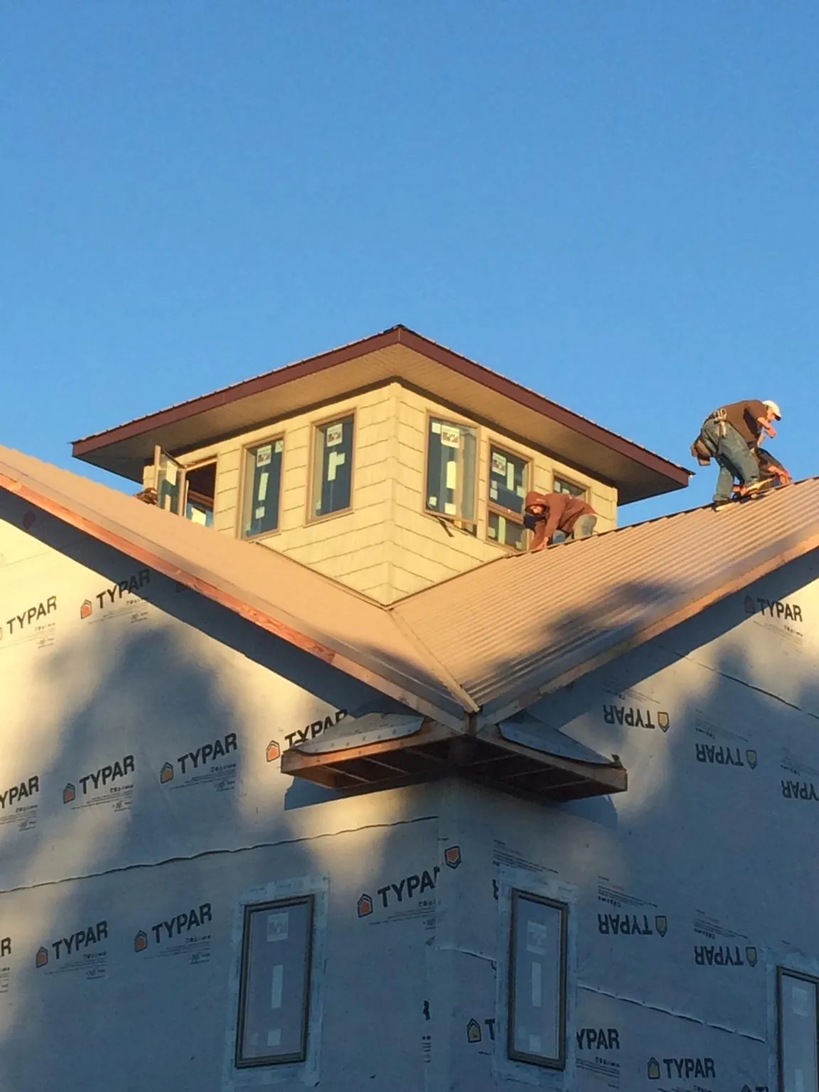 Roofers working around a rooftop cupola on a new metal roof at sunset — Roof Waterproofing in La Valle by Roofing Brothers